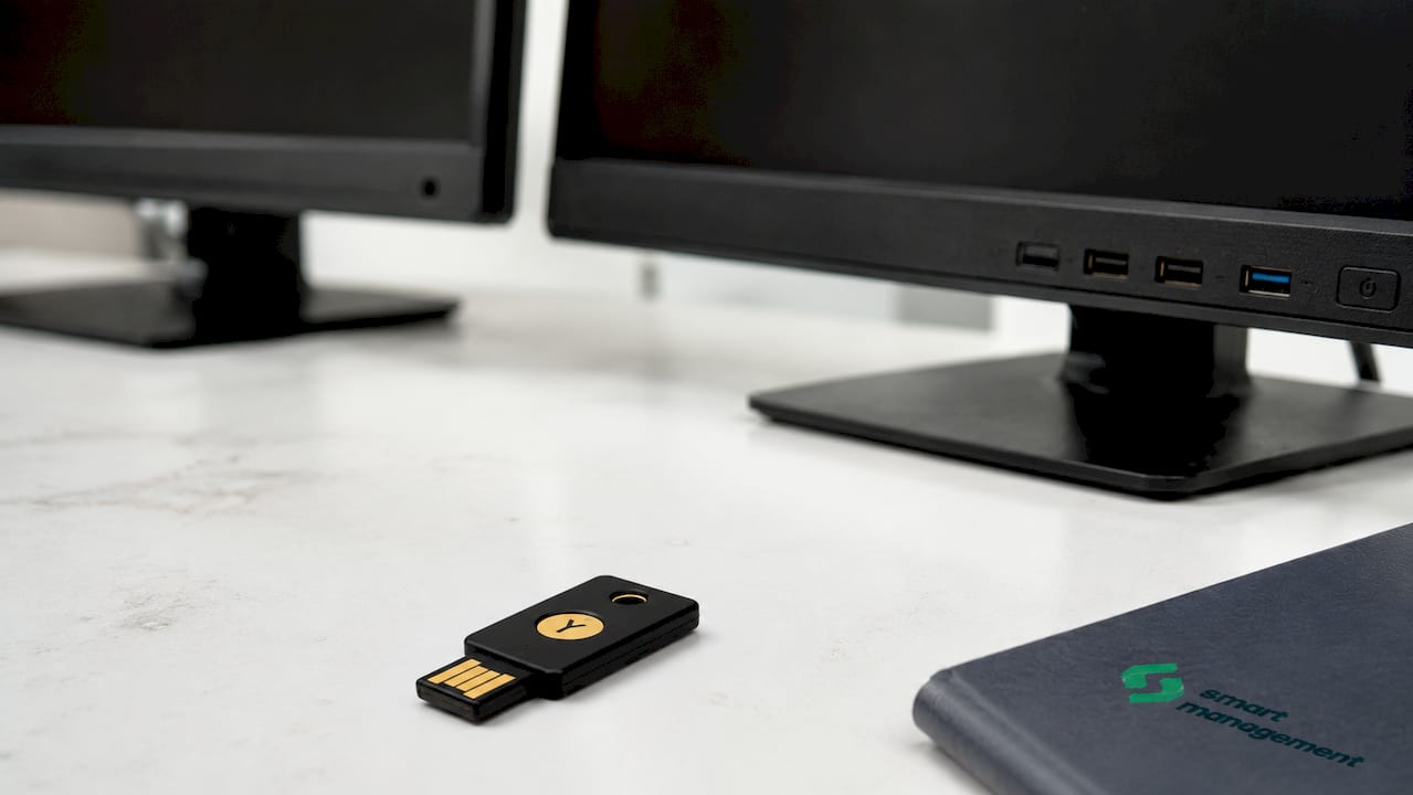 Черна YubiKey лежи върху бюрото в офиса.