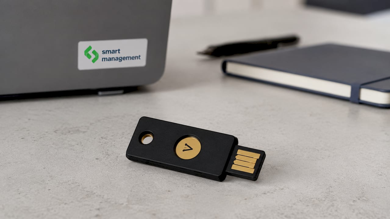 Чер матов YubiKey, поставен върху светъл фон
