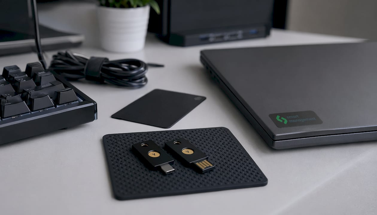 YubiKey устройства и лаптоп са поставени върху офис бюро.